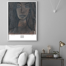 Picture of a light colored sofa and side table with a framed art print on the wall