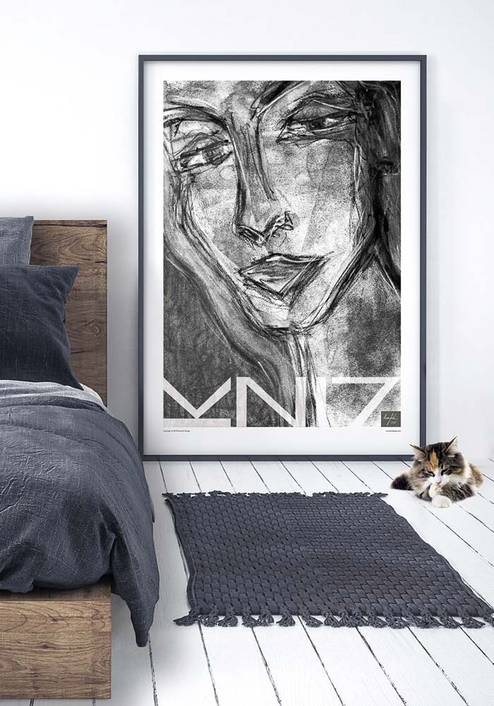 Picture of a bedroom with a large framed portrait art print in black & white portraying a woman, there' also a kitten on the floor.