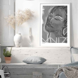 Picture of a bedroom with a framed bw art print portraying a woman